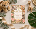 a baby shower invitation with a jungle theme, surrounded by stuffed animals and plants.