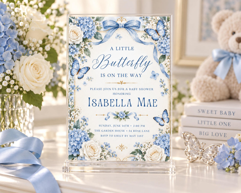 A blue and white baby shower invitation for a baby shower for Isabela Mae, featuring a floral design with blue and white flowers and butterflies.