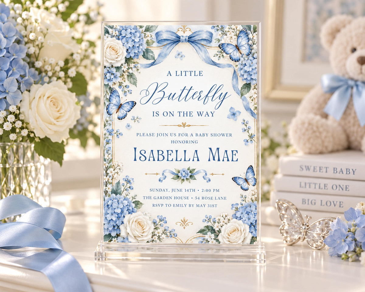 A blue and white baby shower invitation for a baby shower for Isabela Mae, featuring a floral design with blue and white flowers and butterflies.