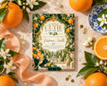 a decorative invitation card with a garden scene, surrounded by oranges, flowers, and a blue and white plate.