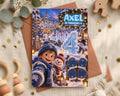A birthday card featuring a snowy winter scene with a young boy, snowmen, and other winter-themed elements. The card has a blue and white color scheme and includes the text "AXEL IS TURNING 4".