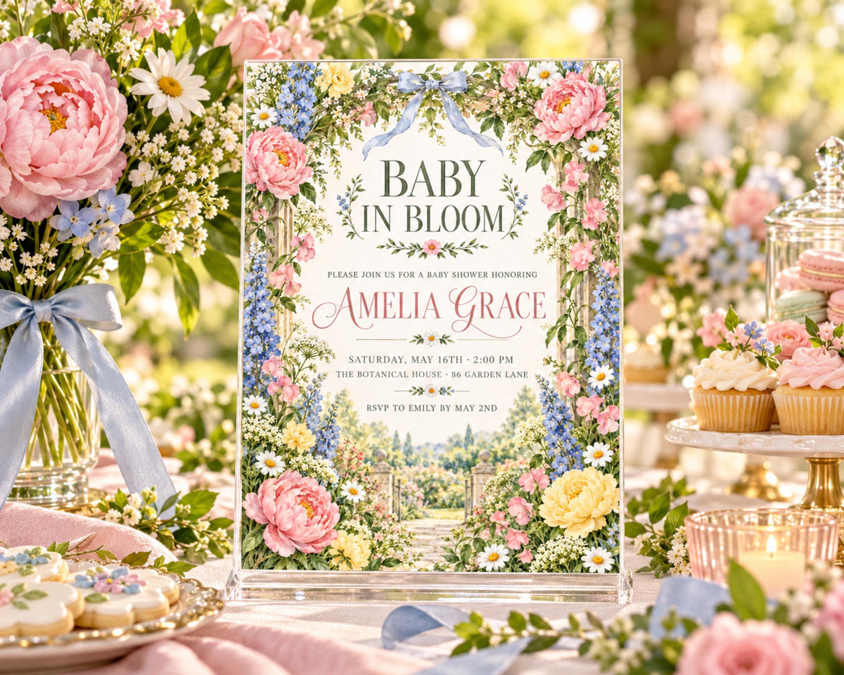 a beautifully decorated baby shower invitation with a floral design, surrounded by various desserts and flowers.