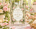The image is a beautifully decorated baby shower invitation featuring a floral design with pink and white flowers, surrounded by a lush garden setting.