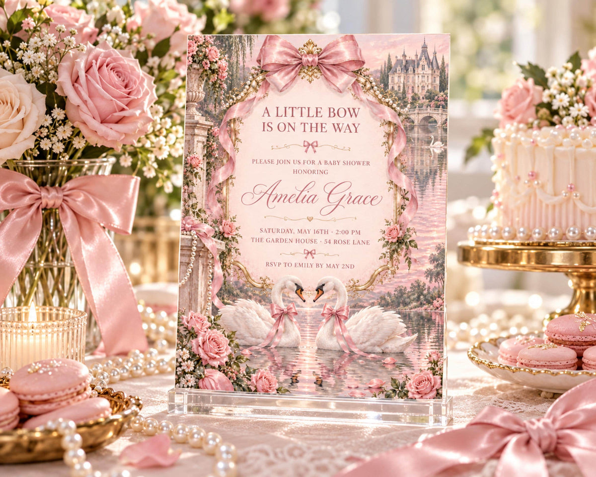 A pink and white baby shower invitation featuring a castle and swans, surrounded by pink flowers, pearls, and macarons.