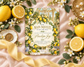 a wedding invitation with a lemon and flower design, surrounded by various decorative elements such as lemons, flowers, and a ribbon.
