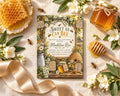 a honeycomb, honey, flowers, a honey dipper, and a honey jar, all arranged around a honeybee-themed invitation card.