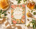 a floral baby shower invitation with honeycomb and flowers, honey, and a honey dipper, along with some honey jars and a ribbon.
