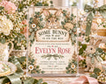 The image is a baby shower invitation featuring a cute bunny design, surrounded by flowers and other decorative elements.