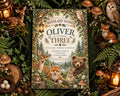 The image is a birthday invitation featuring woodland animals such as deer, foxes, and bears, surrounded by a forest setting and decorated with lanterns, pine cones, and flowers.