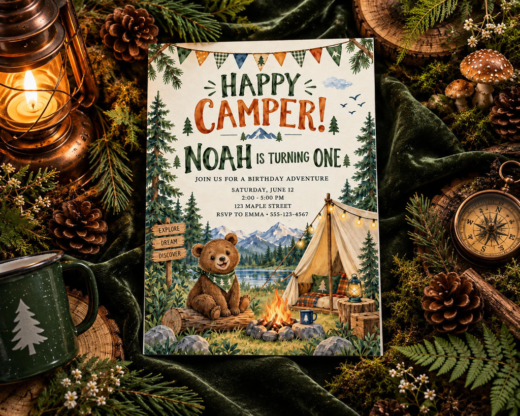 The image is a birthday invitation for Noah, who is turning one, featuring a teddy bear, a tent, and a campfire. The invitation is surrounded by pine cones, a lantern, and other camping-themed decorations, creating a festive and adventurous atmosphere.